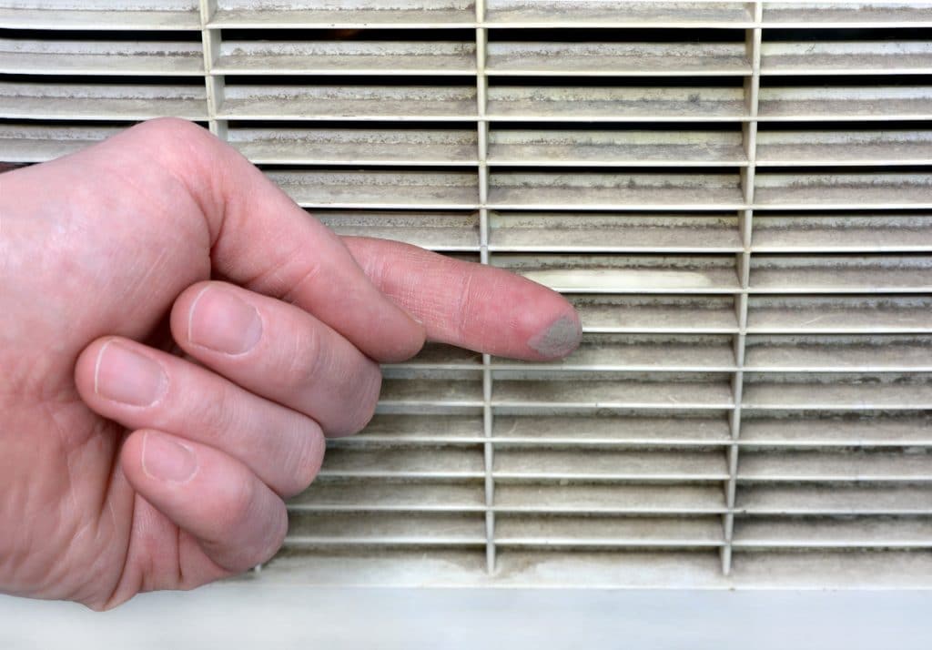 Person checks the contamination of the ventilation grill by swiping a finger along it