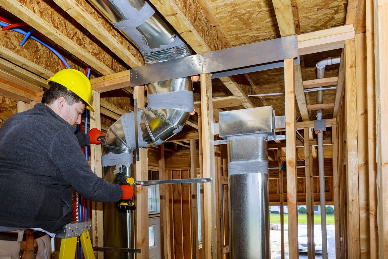 Construction worker assembling ventilation system
