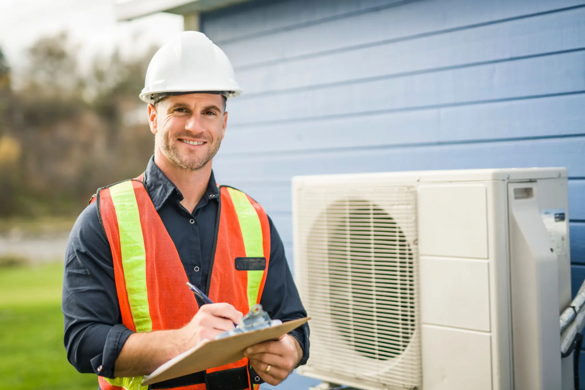 Technician inspecting an outdoor air conditioning unit with clipboard.