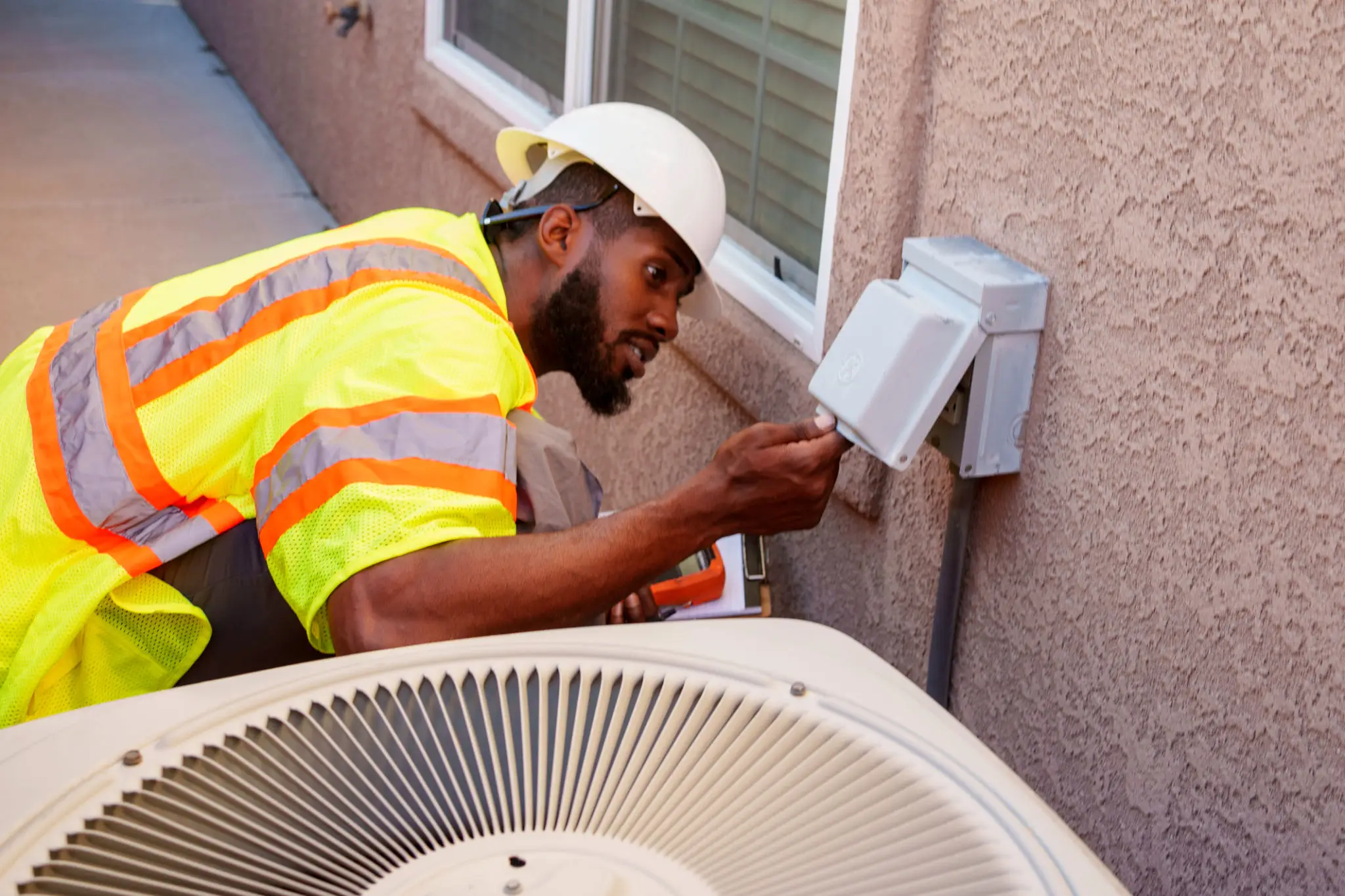 Technician inspecting an outdoor electrical meter box.