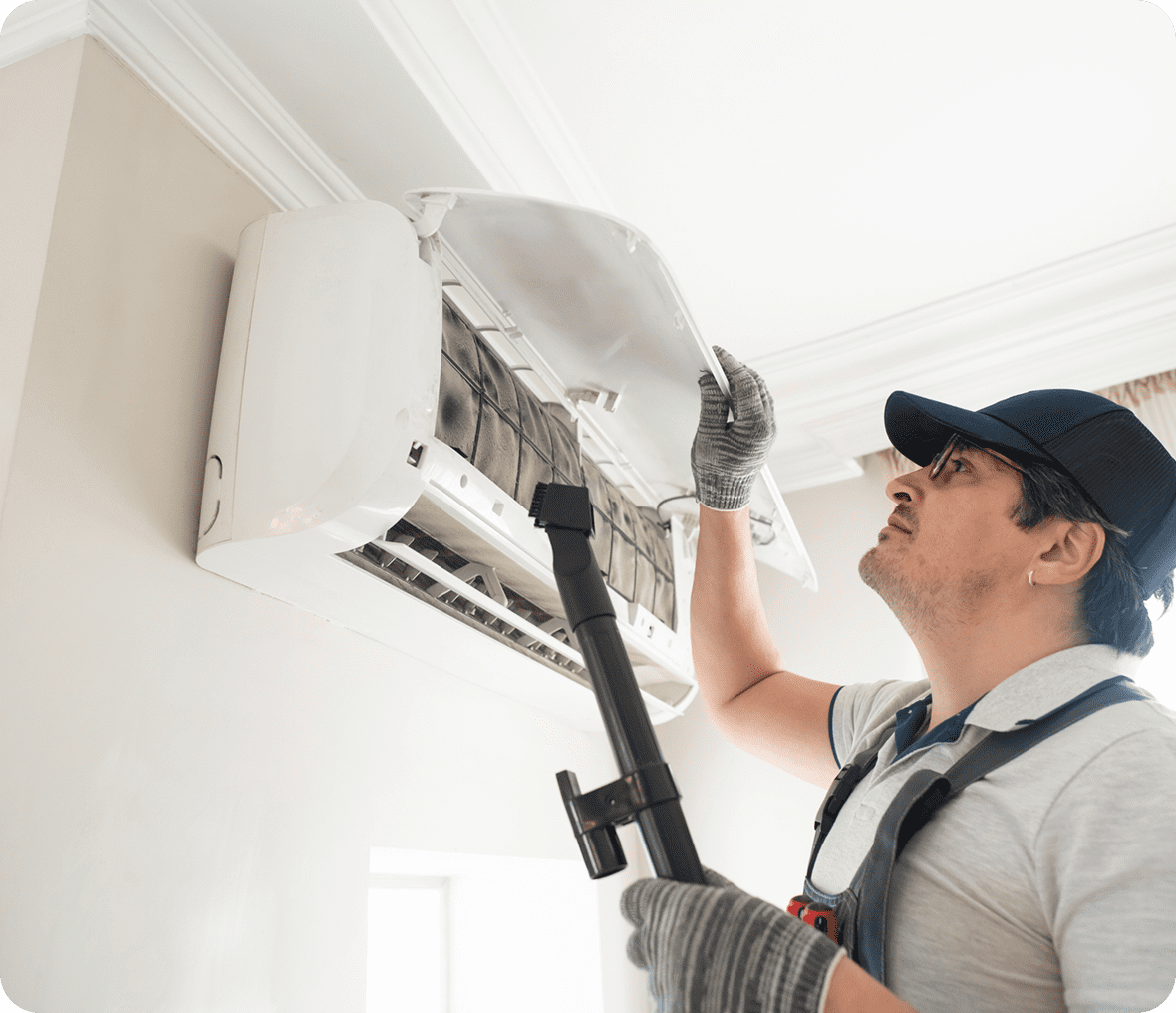 Worker servicing AC unit indoors