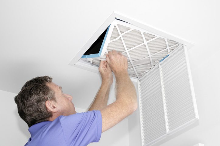 Ceiling vent maintenance by a man